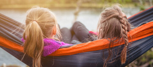 Deux fillettes se reposant au bord de l'eau dans un hamac